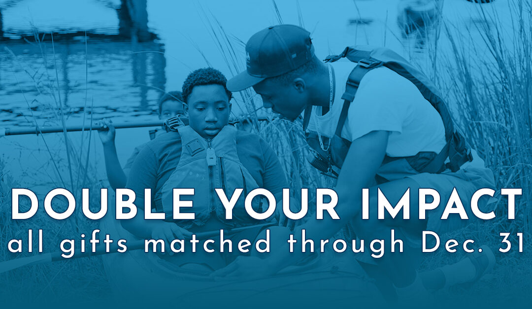 Double Your Impact - Student helping younger student launch a kayak